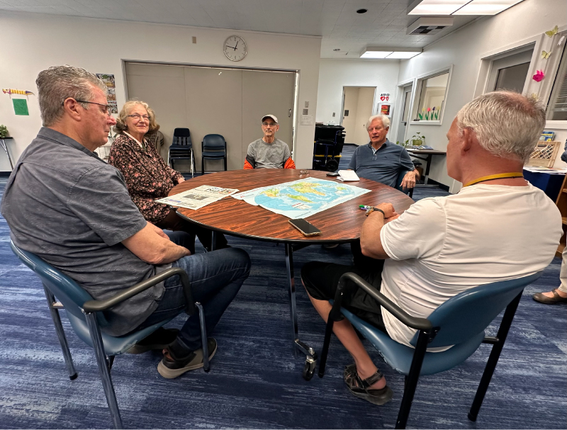reach-Supportgroup A group of five people sitting at a round table during a support group meeting